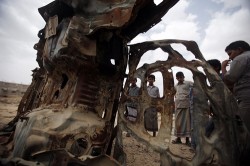 Boys gather near the wreckage of car destroyed last year by a U.S. drone air strike targeting suspected al Qaeda militants in Azan