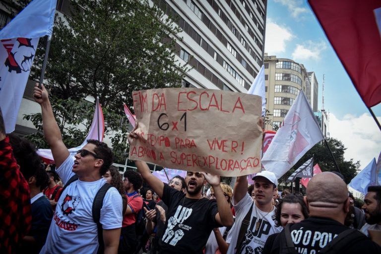 Militantes da UP levantam cartaz pelo fim da escala 6x1 no ato de Primeiro de Maio em São Paulo. Foto: Arthur Rodrigues (JAV/SP)