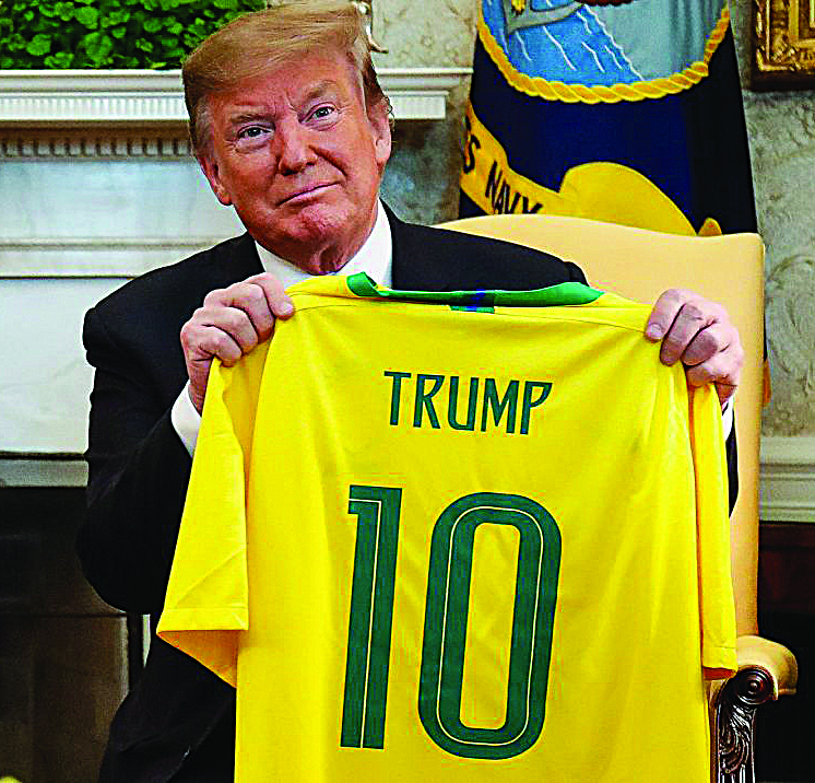 Trump Brasil. Trump ganhou do seu capacho Bolsonaro uma camisa da CBF. Foto: ATS